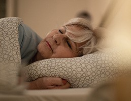A woman resting after dental implant surgery