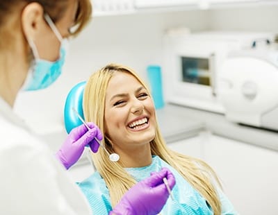 Woman in dental chair laughing