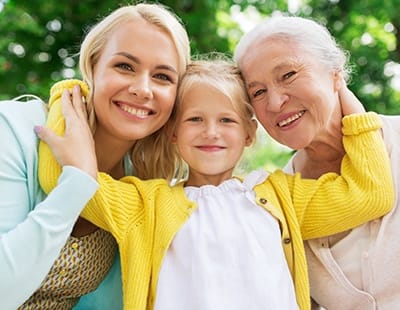 Mother daughter and granddaughter sharing healthy smiles after dental care