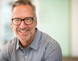Man with glasses smiling after cosmetic dentistry in Ellicott City, MD
