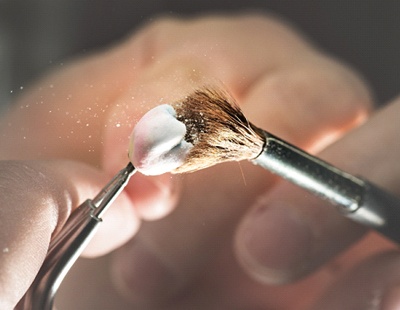 a dental lab technician polishing a crown