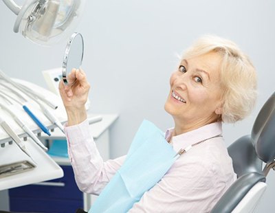 Woman smiles after getting dentures in Ellicott City