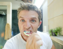 Man with dental implants in Ellicott City brushing his teeth