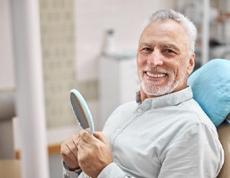 man smiling after getting dental implants in Ellicott City