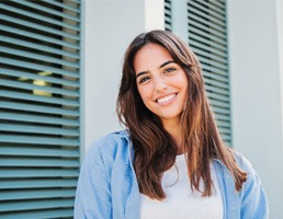 Woman with white teeth smiling while standing outside