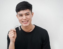 Young man holding an Invisalign aligner