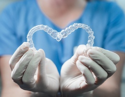 Dentist making a heart with Invisalign aligners