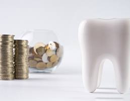 Tooth next to a pile of coins