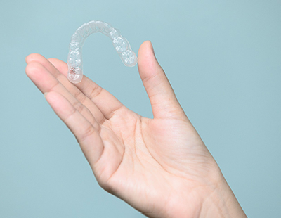 Closeup of patient holding Invisalign clear aligner