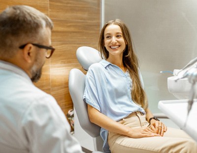 Female patient smiling at dentist at dental appointment 