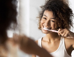 Woman brushing teeth in Ellicott City