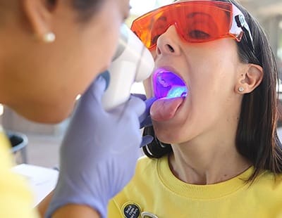 Dentist performing oral cancer screening