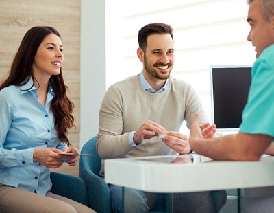 Couple talking to dentist in office about veneers