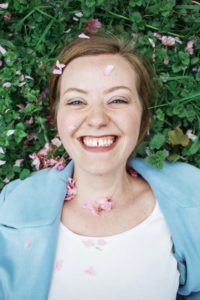 Smiling woman laying in grass